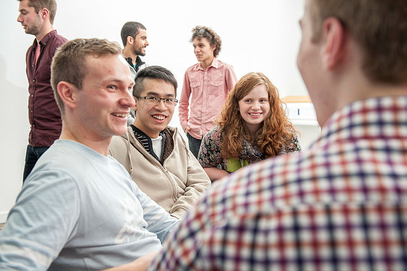 Students sitting down and working in a group.