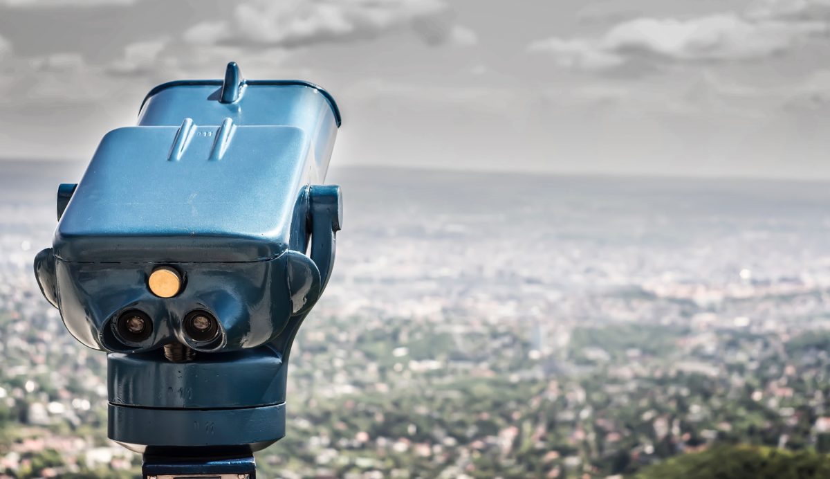 Blue coin operated binocular with cityscape in daytime