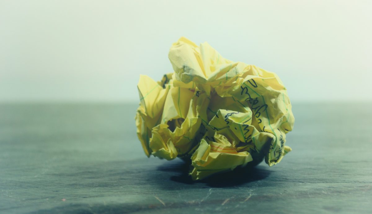 A crumpled ball of yellow paper on the floor to suggest a rejected attempt