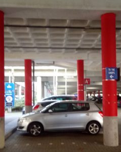 Post-tensioned beams and waffle slab high above a block paved parking area