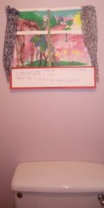 A child's picture above a toilet cistern