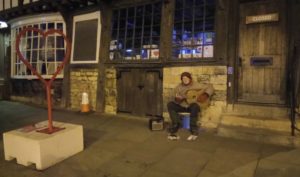 On the streets of Lincoln, a man plays his guitar on the steps of the Information Centre (photo taken with his permission)