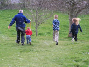 Family running down a hill as snow starts to fall