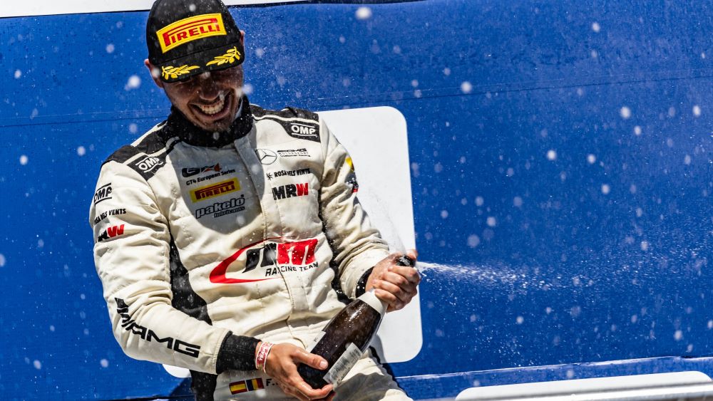 Filip celebrating a win by spraying an open champagne bottle and smiling