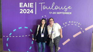 Lilith Ding and Amy Riddle in front of poster