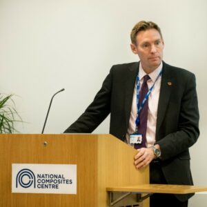 A man in a suit standing behind a lectern.