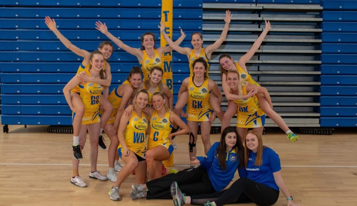 University of Bath netball players in uniform celebrating at a cup final