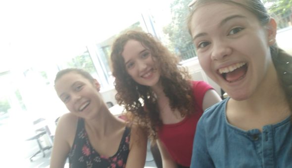 A picture of me with two friends in the library working on our projects