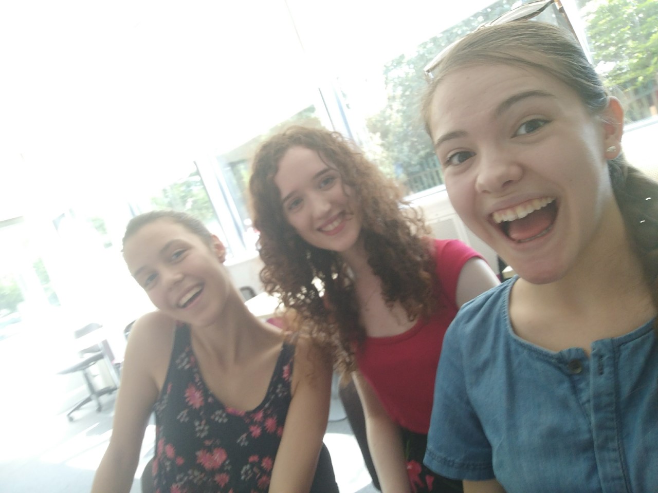A picture of me with two friends in the library working on our projects