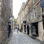 Cobbled street with cobbled buildings on either side of it.
