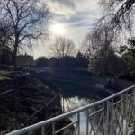 Bridge over a canal, with trees on the side.