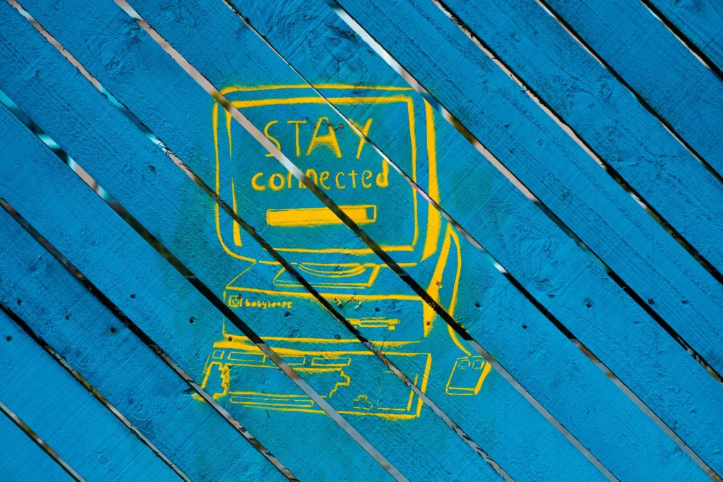 yellow graphic of a computer with the words stay connected on the screen with a blue background