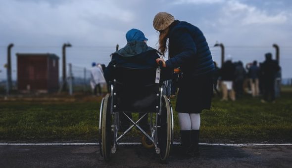 Two women, one in a wheelchair talking.