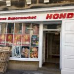 Front of the Chinese supermarket "Hondo" showing the entrance and posters.
