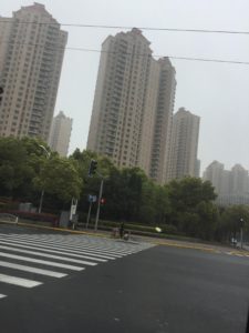 Tall, beige buildings, with trees in the foreground.