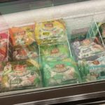 Freezer drawer showing colourful packages of frozen dumplings.