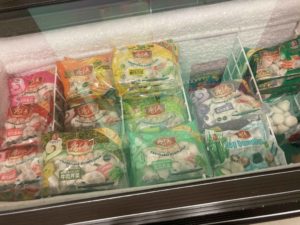 Freezer drawer showing colourful packages of frozen dumplings.