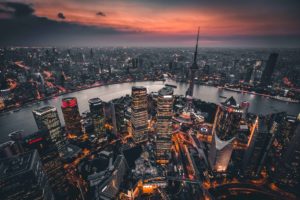 Landscape of skyscrapers at dusk in Shanghai, with lights illuminating the city.