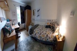 Photo of student accommodation. Everything has been unpacked now. The desk has folders and there are some posters on the walls