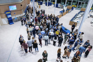 Large group of people networking, on the ground floor new School of Management building
