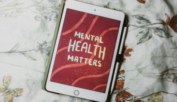 Electronic tablets says mental health matters on red background