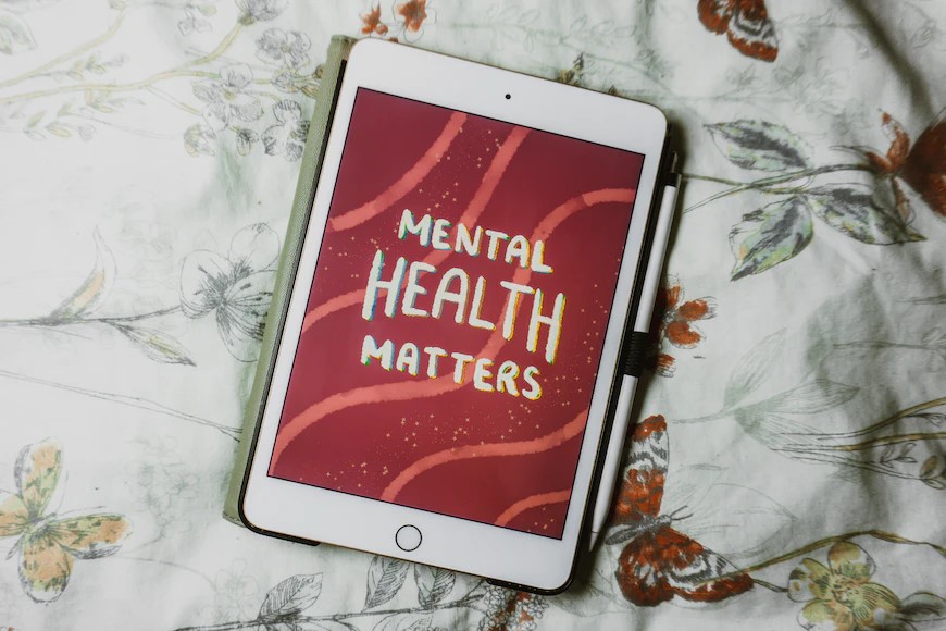 Electronic tablets says mental health matters on red background